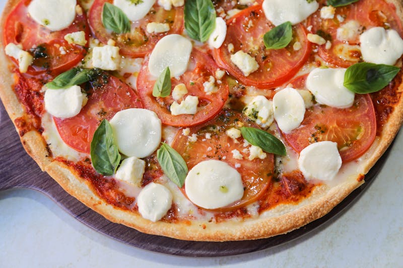 Margherita thin crust pizza with fresh basil and tomato